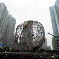 Large globe sculpture in central Chongqing surrounded by high-rise buildings, symbolizing modern development