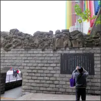 Entrance to the Stilwell Museum in Chongqing with a stone wall relief depicting wartime scenes