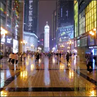 Crowded plaza at Liberation Monument illuminated by bright lights at night