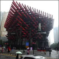 Guotai Arts Center in Chongqing with red and black interlocking wooden beams inspired by traditional Chinese architecture