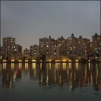 Residential buildings reflected in calm water at night in Guangzhou.