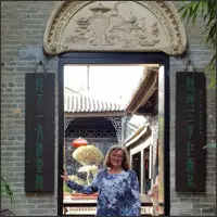 Standing beneath an ornate doorway in Yuyin Shanfang Garden.