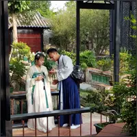 Two visitors wearing traditional Chinese clothing in the garden.