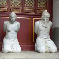 Kneeling statues of Qin Hui and Lady Wang displayed outside a temple building in Guandu Ancient Town.