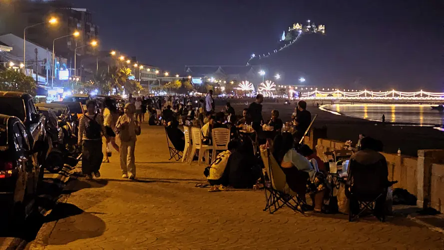 Families and friends gathered along the Prachuap seawall at dusk