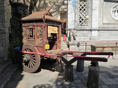 Ancient-style carriage displayed in front of a tea museum in Kunming.