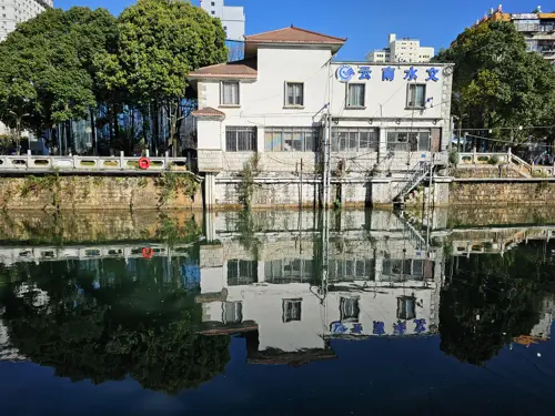 Reflection of the “Yunnan Hydrology” building mirrored almost perfectly in the calm water of the Panlong River in Kunming.