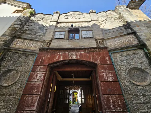Entrance to a modern building in Kunming with a large frame painted to resemble rusted steel, creating the illusion of aged metal.