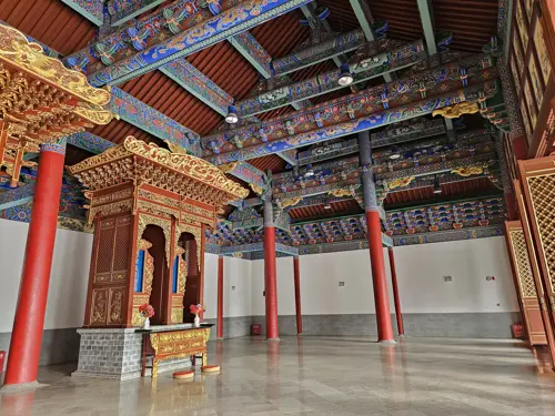 Interior of the main temple hall at Wenmiao with colorful painted beams and decorative ceiling, largely empty without statues or furnishings.